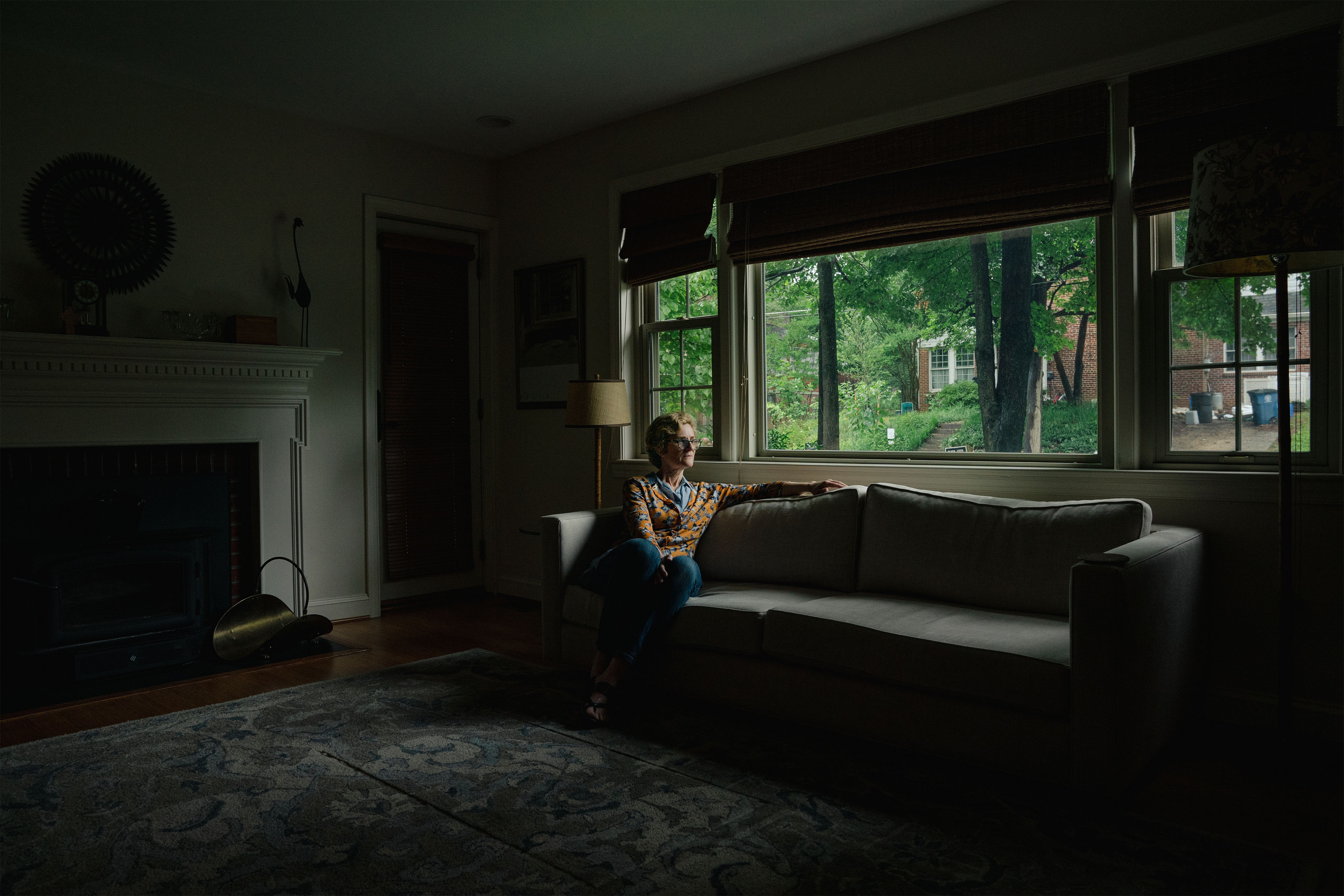 A photo of a woman sitting on a couch, posing for a portrait.