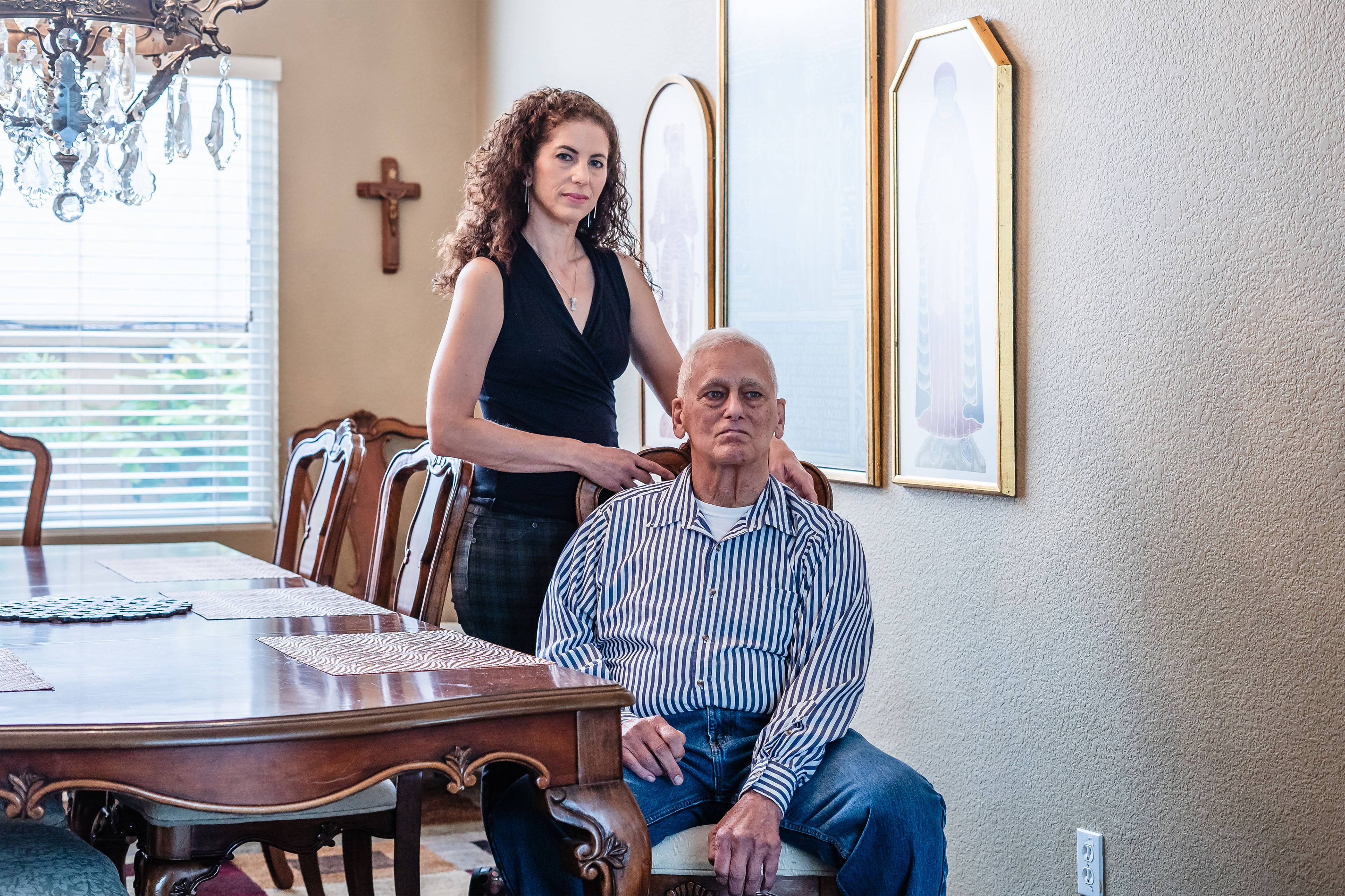 A photo of a daughter standing for a portrait with her elderly father.