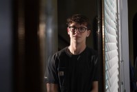 A photo of a teenager standing indoors for a portrait.