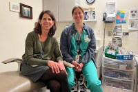 Pediatrician Patricia Braun (left) and Valerie Cuzella (right) sit side by side in a dental exam room.