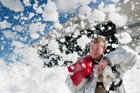 A photo of a military firefighter swiping away foam bubbles blown into the air.