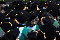 A photo of medical students at a graduation ceremony. They are seen from behind with their graduation tams and tassels facing the camera.