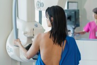 A photo of a woman receiving a mammogram.