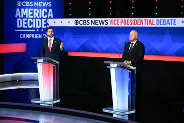 A photo of JD Vance and Tim Walz standing at podiums in a TV studio.