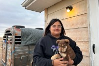 Katherine Goodlow holds a brown puppy outside her grandmother's home.