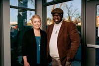 A white woman and a Black man stand together.