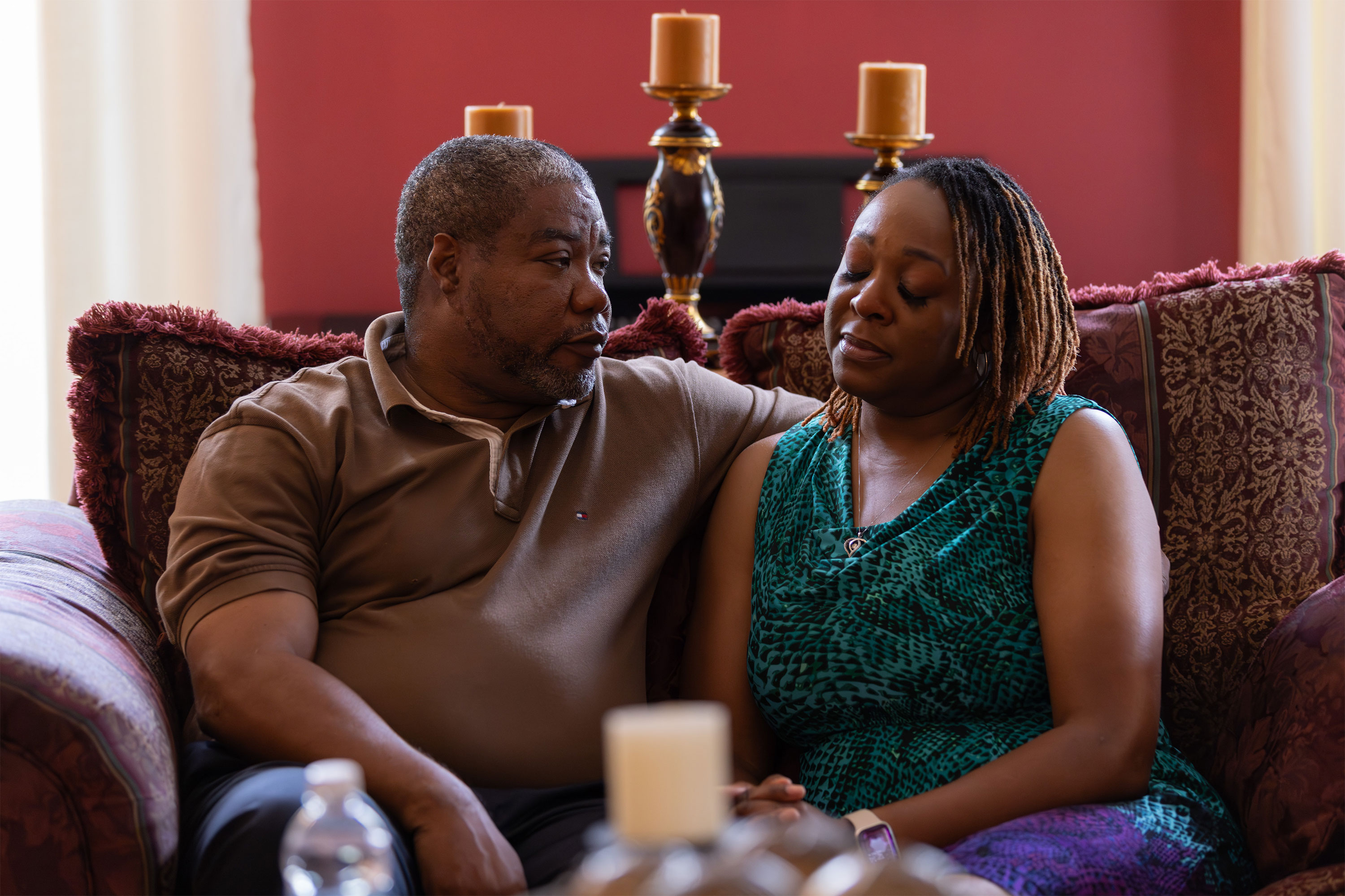 A photo of a husband and wife seated next to each other with serious expressions on their faces.