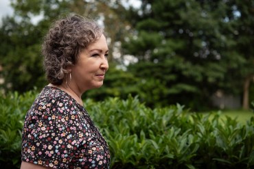 A photo of a woman standing outside.