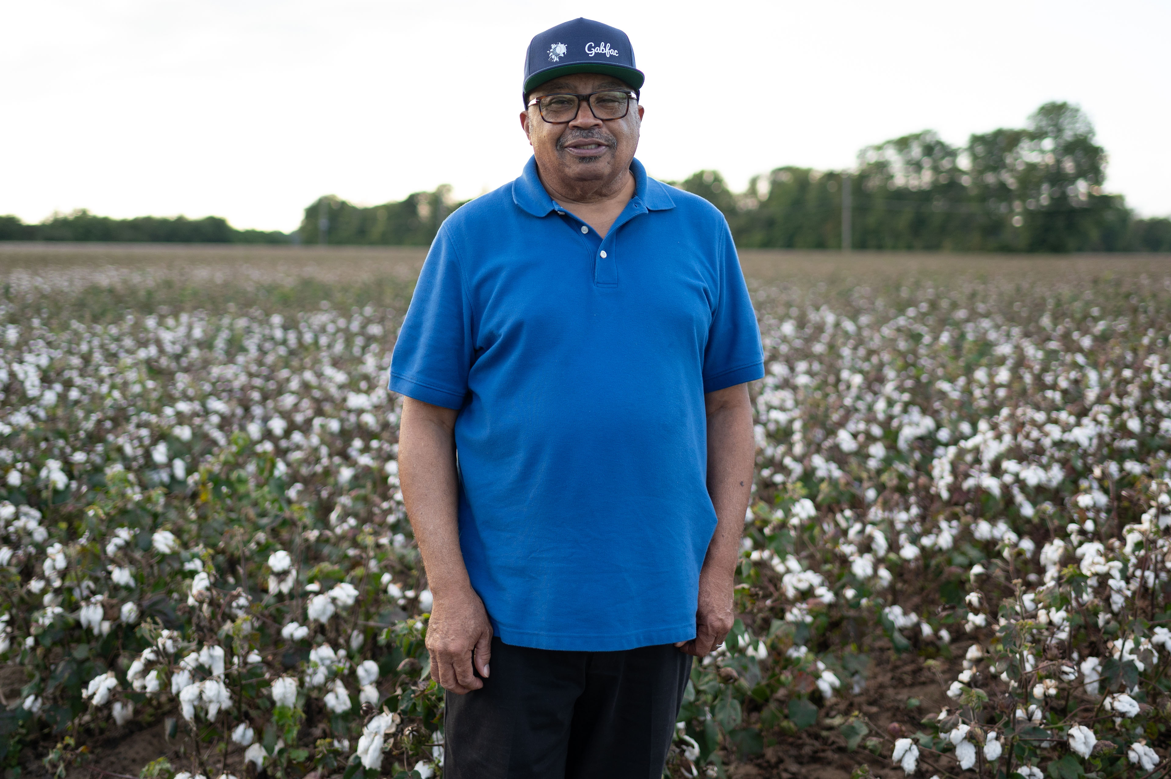 Wilbon Anthony stands in a cotton field and looks towards the camera.